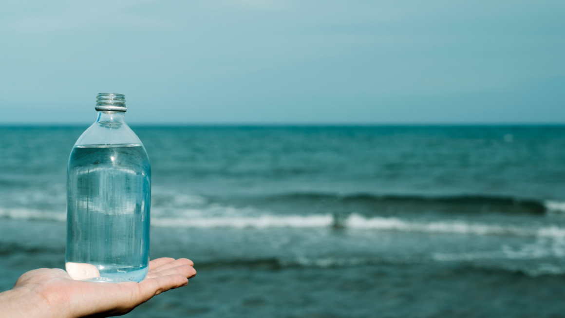 water in a bottle in front of the beach